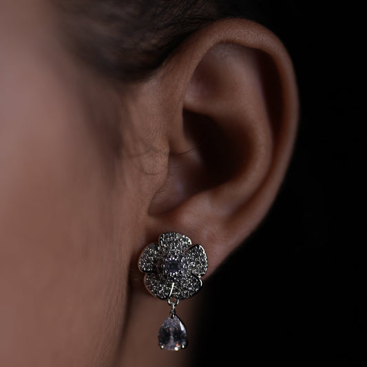 Close-up of a diamond earring on an ear with a blurred background