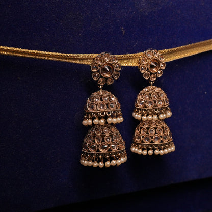 Pair of gold earrings on a blue cushion